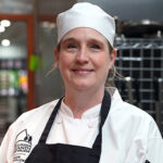 Posed photo of Kat Walker in her chef gear, in the Culinary Center.