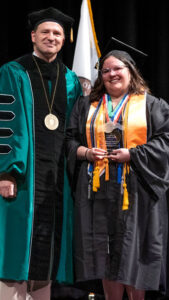 Adelyn Dull receceiving an award from President Dr. Steve Nunez at Commencement.