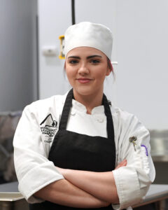 Trininty Hyatt, chef student, posing in the Culinary Center.